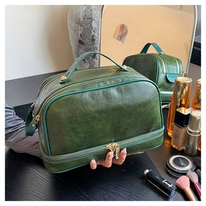 Detail of vintage green faux leather makeup bag with double layer zipper and handle