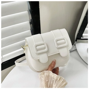 Détail du sac selle blanc montrant la texture en cuir PU mat et doubles sangles