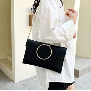 Détail de la pochette enveloppe noire avec boucle anneau doré et chaîne fine