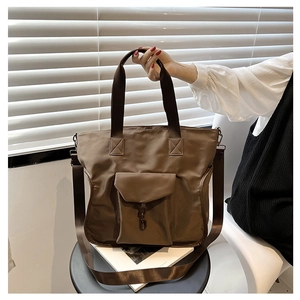 Detail of nylon tote bag featuring cargo front pocket and adjustable shoulder strap