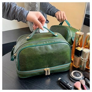 Macro view of a dark green vintage double-layer cosmetic bag with gold zippers and rivets