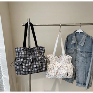 Detail of canvas tote bags with drawstring side pockets in floral and checkered patterns