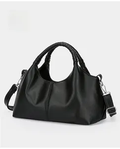 Close-up of black pebbled leather handbag with woven handles and silver hardware detail