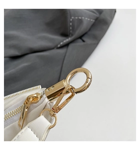 Close-up of premium golden metal hardware and zipper on the white leather dumpling bag