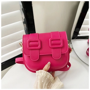 Détail du sac selle fuchsia montrant la texture du cuir PU et la boucle carrée