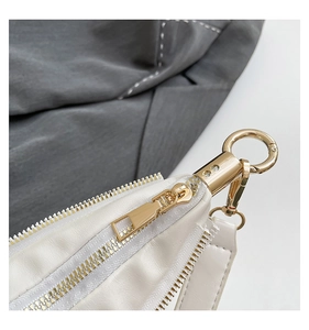 Macro shot of white leather texture with premium gold zipper and swivel ring hardware