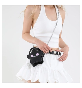 Detail view of mini black star-shaped crossbody bag with cute face and silver chain
