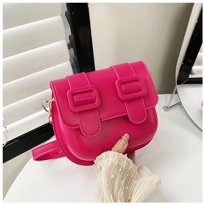 Détail du sac selle rose vif avec doubles boucles rectangulaires et bandoulière