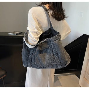 Detail of large dark grey washed denim tote bag with vintage texture and square pocket