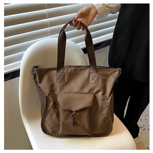 Detail of a large capacity waterproof nylon tote bag in coffee brown with metal chain accent