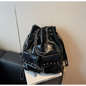 Detail of glossy black PU leather bucket bag with silver studs and chain straps