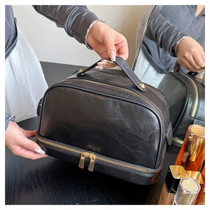 Detail of black large capacity makeup bag with gold zippers and pebble grain PU leather