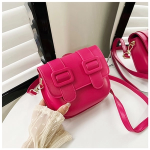 Vue de dessus d'un sac bandoulière rose fuchsia avec boucles dorées et texture lisse