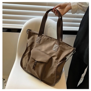 Detail of dark brown waterproof nylon tote bag with decorative chain and wide straps