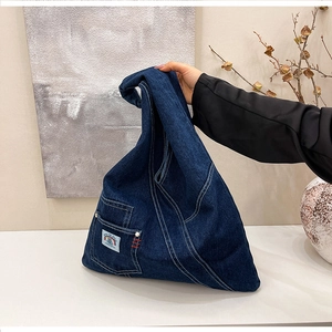 Close-up of vintage washed denim tote bag with rainbow space patch and functional pocket