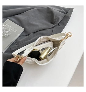 Top view of cream dumpling bag interior showing space for phone and makeup accessories