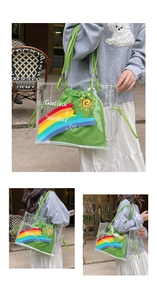 Detail view of transparent PVC tote bag with rainbow print and green drawstring inner bag