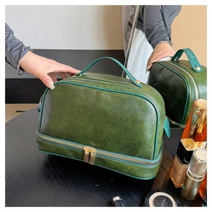 Detail view of the dark green faux leather cosmetic bag with dual layered zippers
