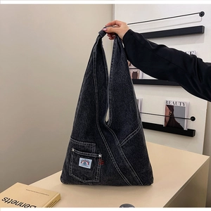 Close-up of charcoal washed denim hobo bag featuring white contrast stitching and pocket