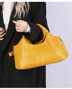 Macro view of bright yellow litchi pattern leather tote with woven handle detail