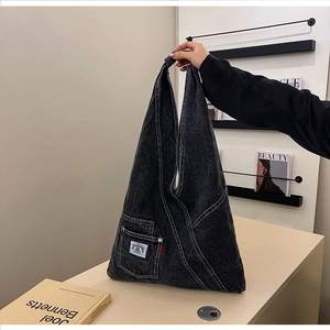 Detailed view of dark grey washed denim hobo bag with contrast stitching and patch