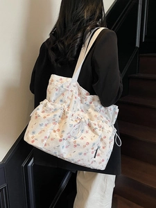 Floral print tote bag in cream white with multi-pocket design and drawstring details