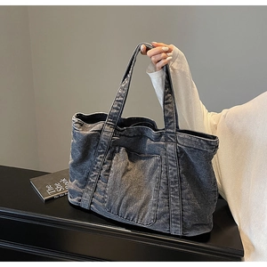 Detail shot of the acid wash denim tote bag showing fabric texture and front pocket