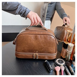 Detail of vintage brown large capacity makeup bag with double layer zippers and top handle