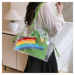 Detail view of transparent PVC beach tote with green inner bag and colorful sunshine print