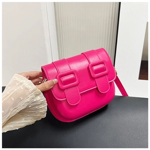 Détail du sac selle en similicuir rose vif avec doubles boucles et coutures précises