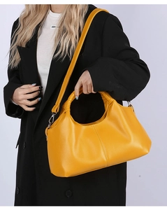 Detail of yellow lychee pattern handbag with braided handle and silver hardware accent