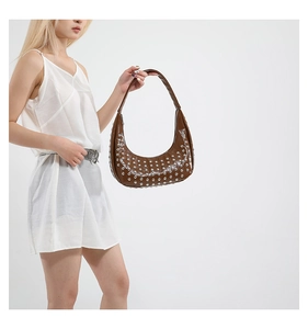 Detailaufnahme der braunen Halbmond-Tasche mit silbernen Nieten und Punk-Stil-Verzierung