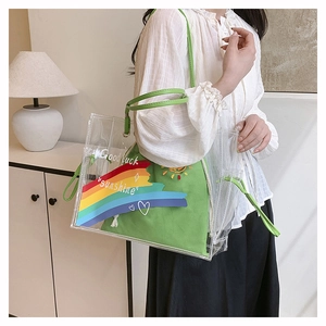 Detail of transparent PVC beach bag with green canvas insert and rainbow sun embroidery