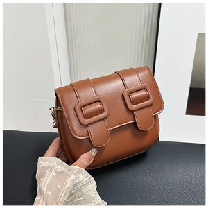 Détails d'un sac à main vintage en cuir marron-rouge avec boucles et bouclerie dorée chic