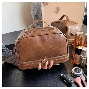 Close-up of vintage brown PU leather cosmetic bag with double zippers and sturdy handle