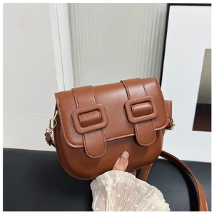 Gros plan du sac besace marron avec deux boucles et détails de crochets en métal doré