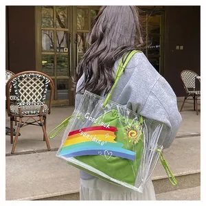 Detailed shot of transparent PVC tote bag with green canvas inner pouch and rainbow prints