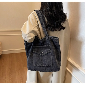 Detailed back view of a large vintage washed denim tote bag with front pocket detail