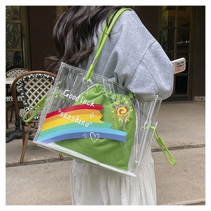 Close-up of clear PVC beach tote with green inner pouch and colorful graffiti print