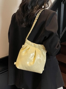 Quilted cream leather bucket bag with gold chain strap shown on professional model