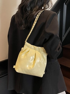 Yellow quilted leather chain bucket bag for women with modern drawstring closure