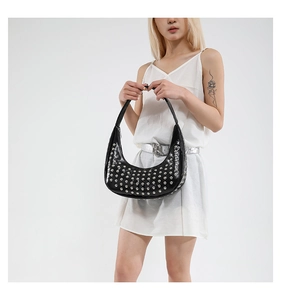 Detail der schwarzen Punk-Tasche mit silbernen Nieten, getragen von einem Model
