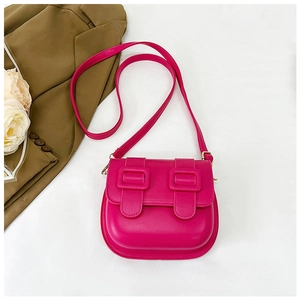 Détail du sac selle rouge rose en similicuir avec double boucle et design de fond arrondi