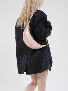 Pink crescent dumplings bag in vegan leather on model with a gold metal clasp