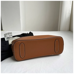 Detail shot of brown leather tote bottom with white contrast stitching and reinforced base