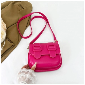 Détail d'un mini sac besace en cuir PU magenta avec des boucles décoratives