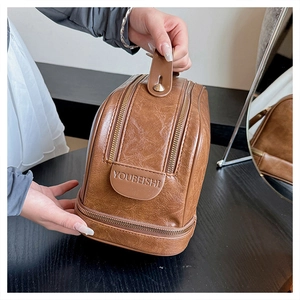 Brown vintage large travel toiletry bag with double zippers and top carry handle detail