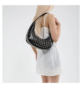Detail der schwarzen Hobo-Tasche mit silbernen Nieten und Glanzoptik am Modell
