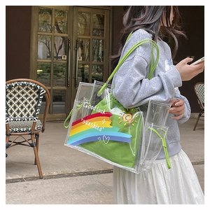 Detail view of transparent PVC tote with rainbow print and green canvas inner pouch