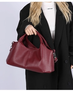 Close-up of the woven leather handle on this deep wine red pebbled leather tote bag
